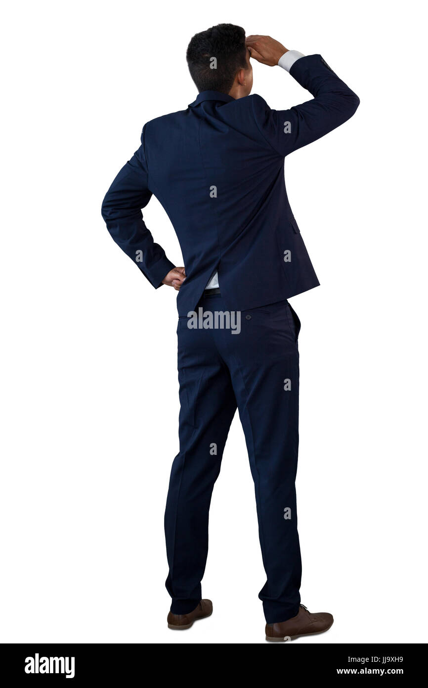 Vista posteriore di imprenditore schermare gli occhi mentre in piedi contro uno sfondo bianco Foto Stock