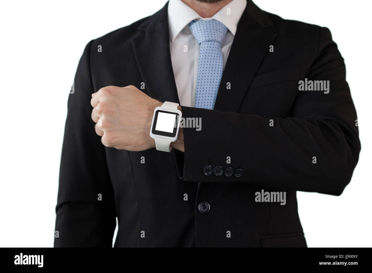 La sezione centrale di imprenditore in tuta che mostra orologio intelligente mentre in piedi contro uno sfondo bianco Foto Stock