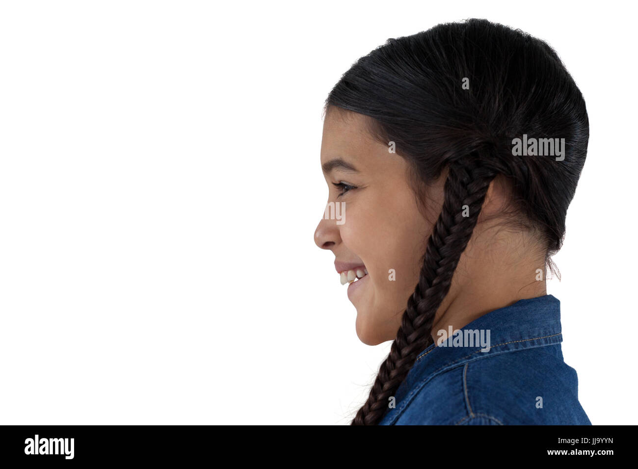 Vista laterale del sorridente ragazza carina in piedi contro uno sfondo bianco Foto Stock