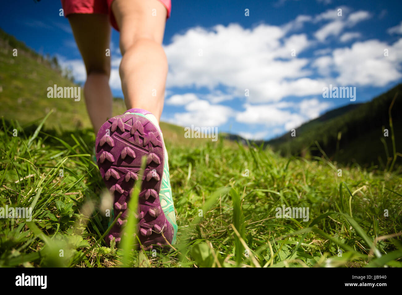 La donna a camminare in montagna in sport scarpe da escursionismo. Jogging, trekking o di formazione al di fuori in estate la natura, ispirando, motivazionali di salute e fitness c Foto Stock