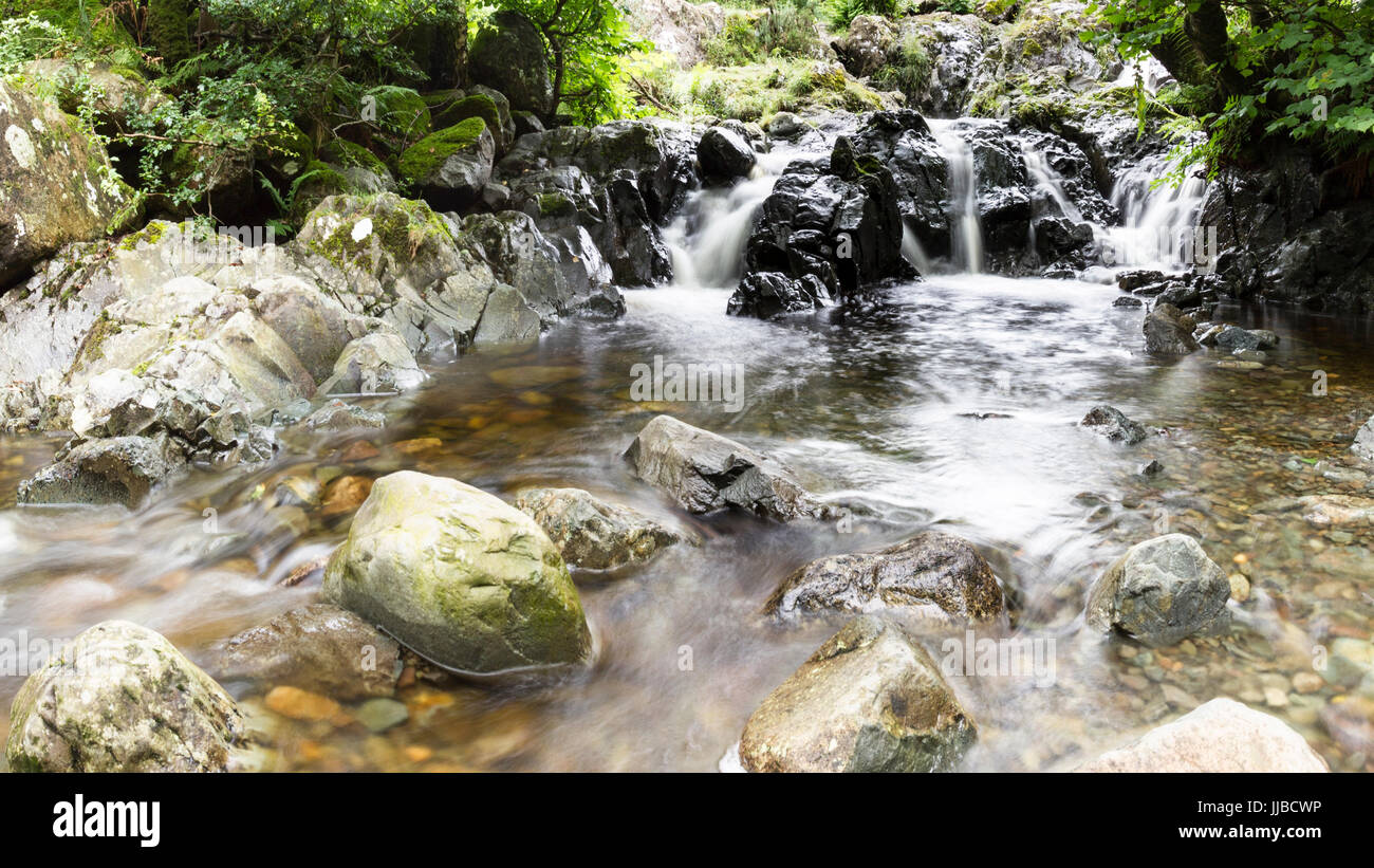 Flussi di acqua attraverso Barrow Beck, sotto il ponte Ashness, Cumbria, Inghilterra. Foto Stock