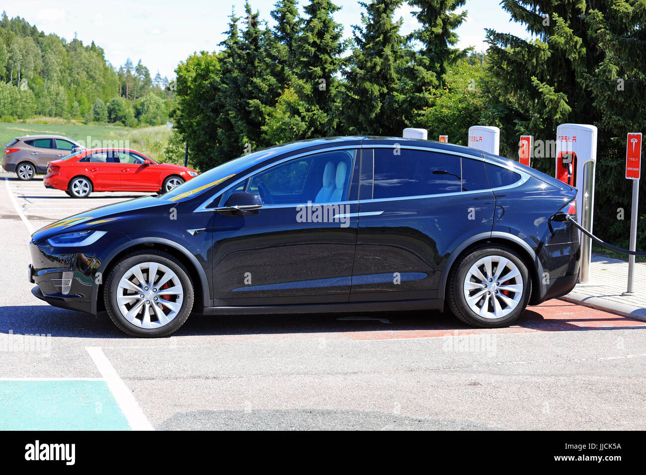 PAIMIO, Finlandia - 14 luglio 2017: Il nuovo modello di Tesla X auto elettrica è in carica di Tesla sovralimentatore. Il modello X è un lusso elettrico crossove Foto Stock