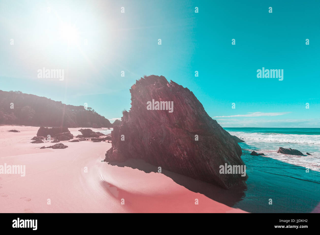 Robusto bella roccia calcarea formazione sulla sabbiosa spiaggia oceano a mezzogiorno la colata ombre lunghe con sun flare e spazio di copia Foto Stock