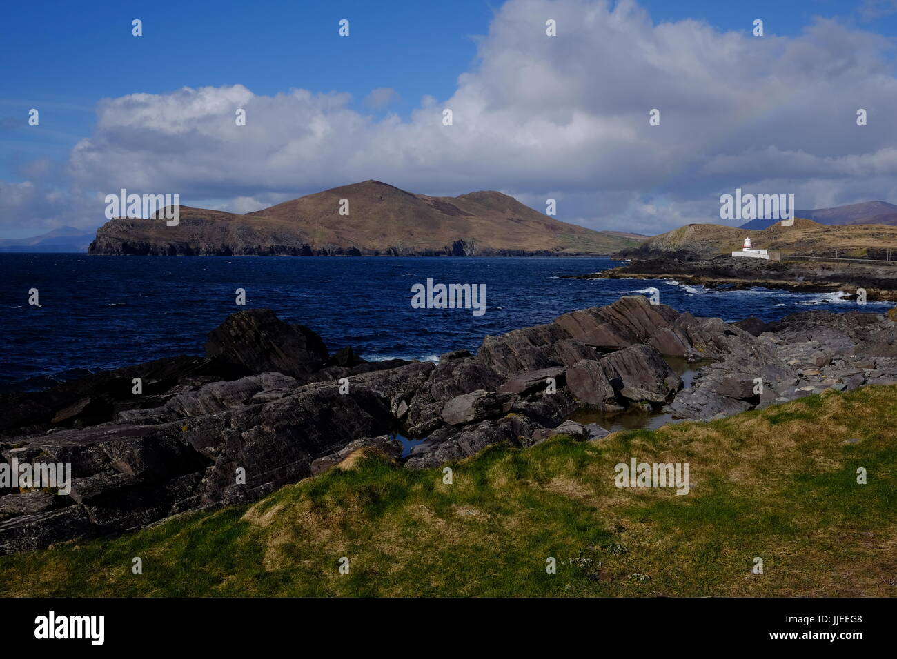 La Valentia Island Lighthouse e il robusto coatline e montagne nella Contea di Kerry, Irlanda Foto Stock