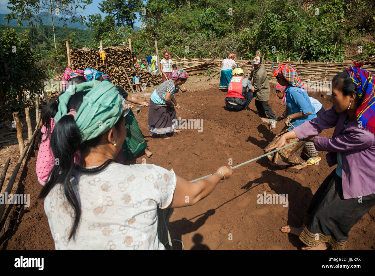 Robert Hahn aiuta a grado a piattaforma piana per una nuova casa in piedi su una sorta di aratro piatto come gli altri tirare in Ban Phak Kung, Laos. Foto Stock