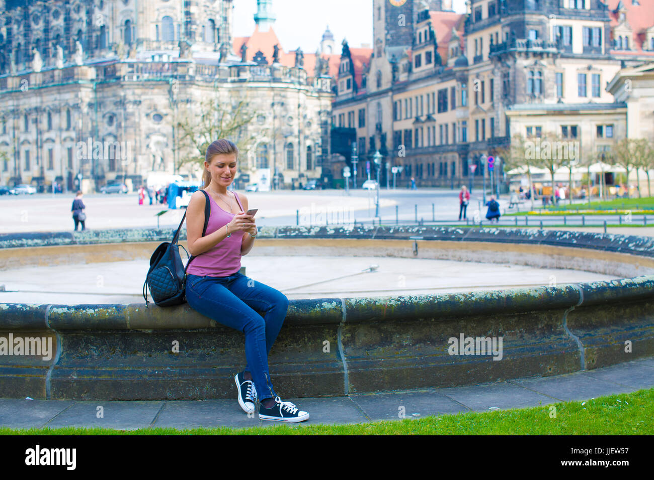 Ragazza utilizza lo smartphone nella vecchia città europea a sunny mattinata estiva in Dresden Foto Stock