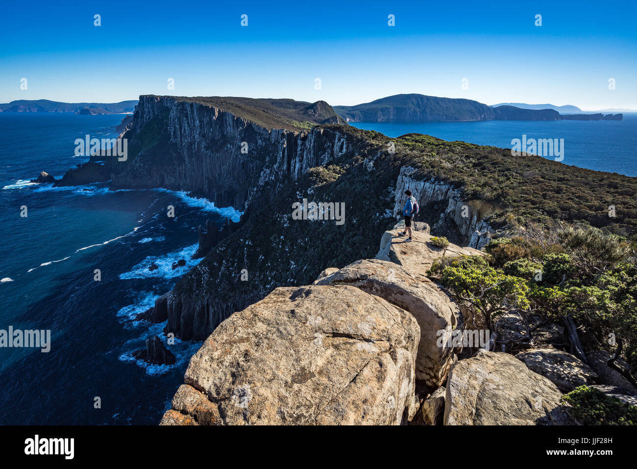 Escursionista permanente sulla scogliera, capo del Pilastro, Tasmania, Australia Foto Stock