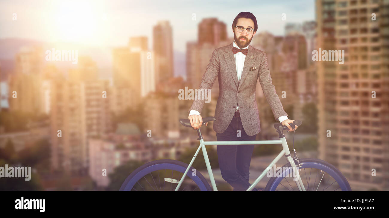 Ritratto di imprenditore con bicicletta contro le torri in città Foto Stock