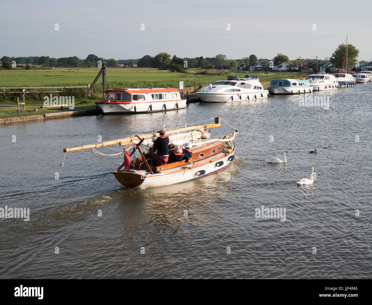 Una barca naviga sul fiume Thurne a Potter Heigham su Norfolk Broads UK in sera la luce del sole in estate Foto Stock