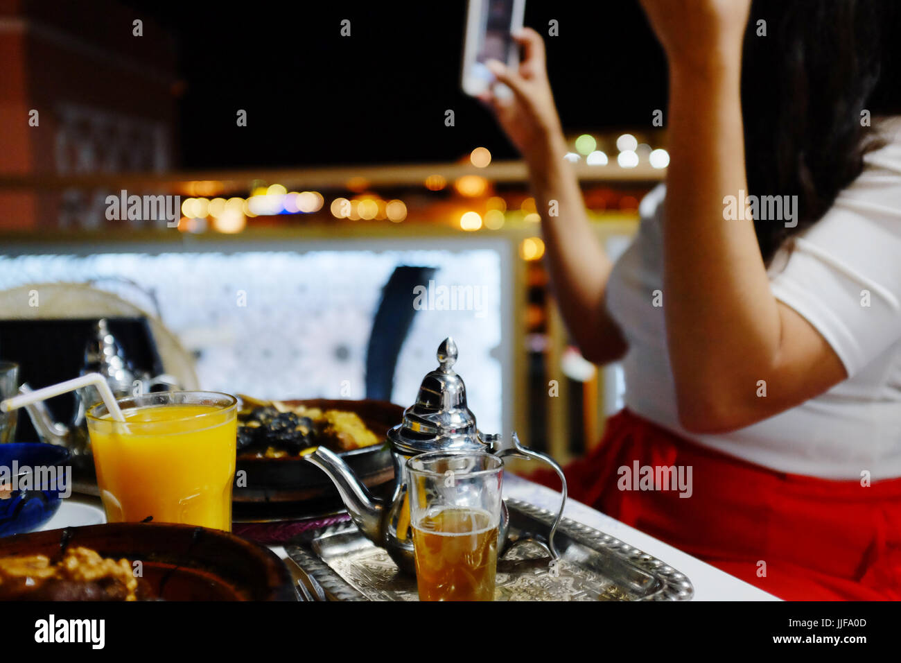Signora scattare foto di cibo, a Marrakech, Marocco, cafe Foto Stock