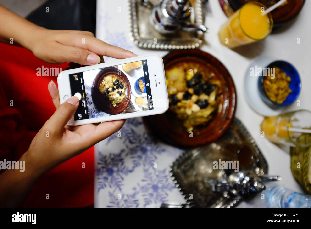 Signora scattare foto di cibo, a Marrakech, Marocco, cafe Foto Stock