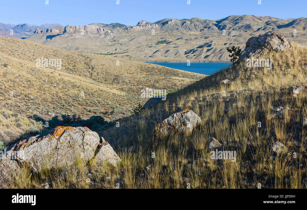Il robusto, prateria arido paesaggio con vista del fiume Shoshone e Montagne Rocciose colline in background in estate vicino a Cody, Wyoming negli Stati Uniti. Foto Stock