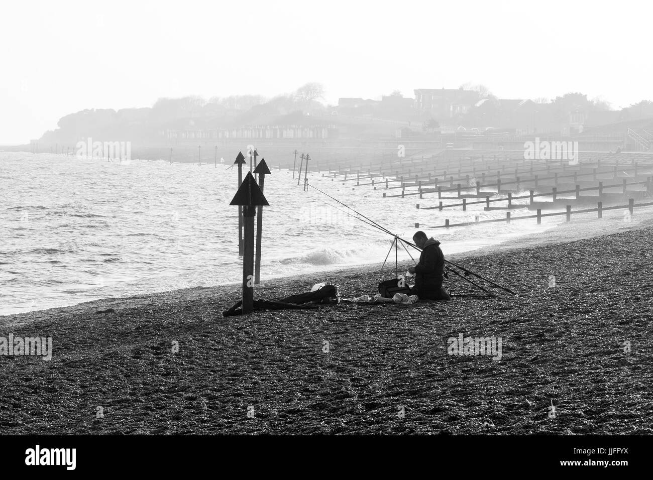 Silhouette di uomo la pesca sulla spiaggia Foto Stock