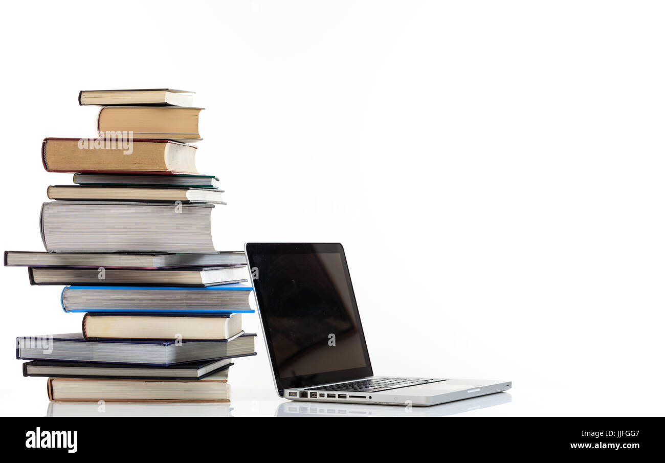 Il concetto di istruzione. Pila di libri e un computer portatile isolato su sfondo bianco - Spazio di copia Foto Stock