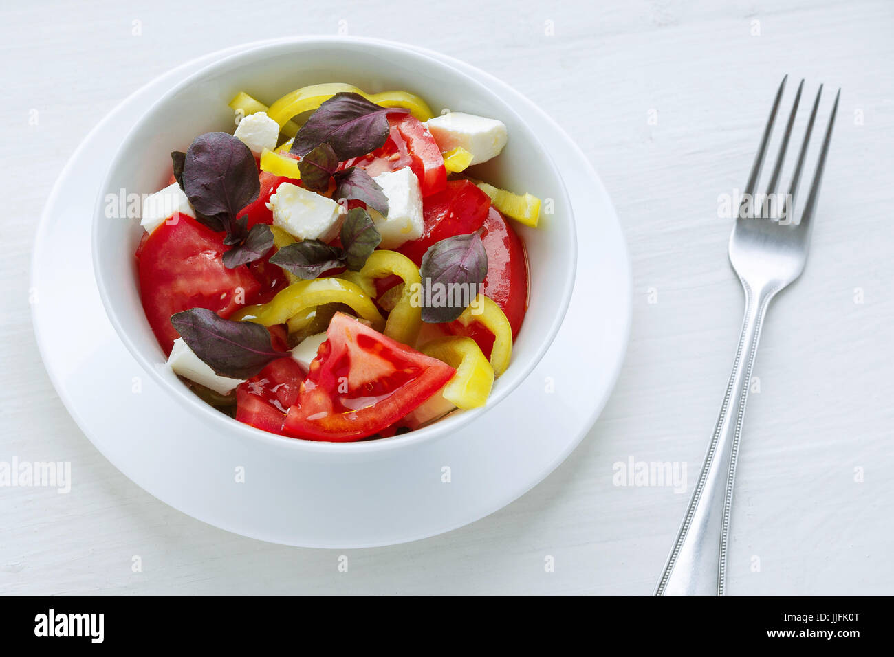 Insalata di verdure con pepe di pomodoro e basilico a sfondo bianco Foto Stock