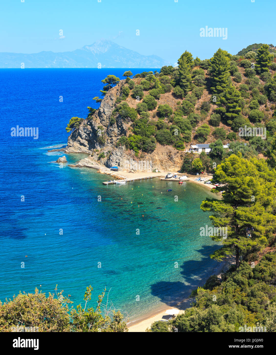 Mare Egeo costa paesaggio con acquamarina acqua e il Monte Athos in mist (Calcidica, Grecia). tre scatti stitch immagine. persone irriconoscibile. Foto Stock