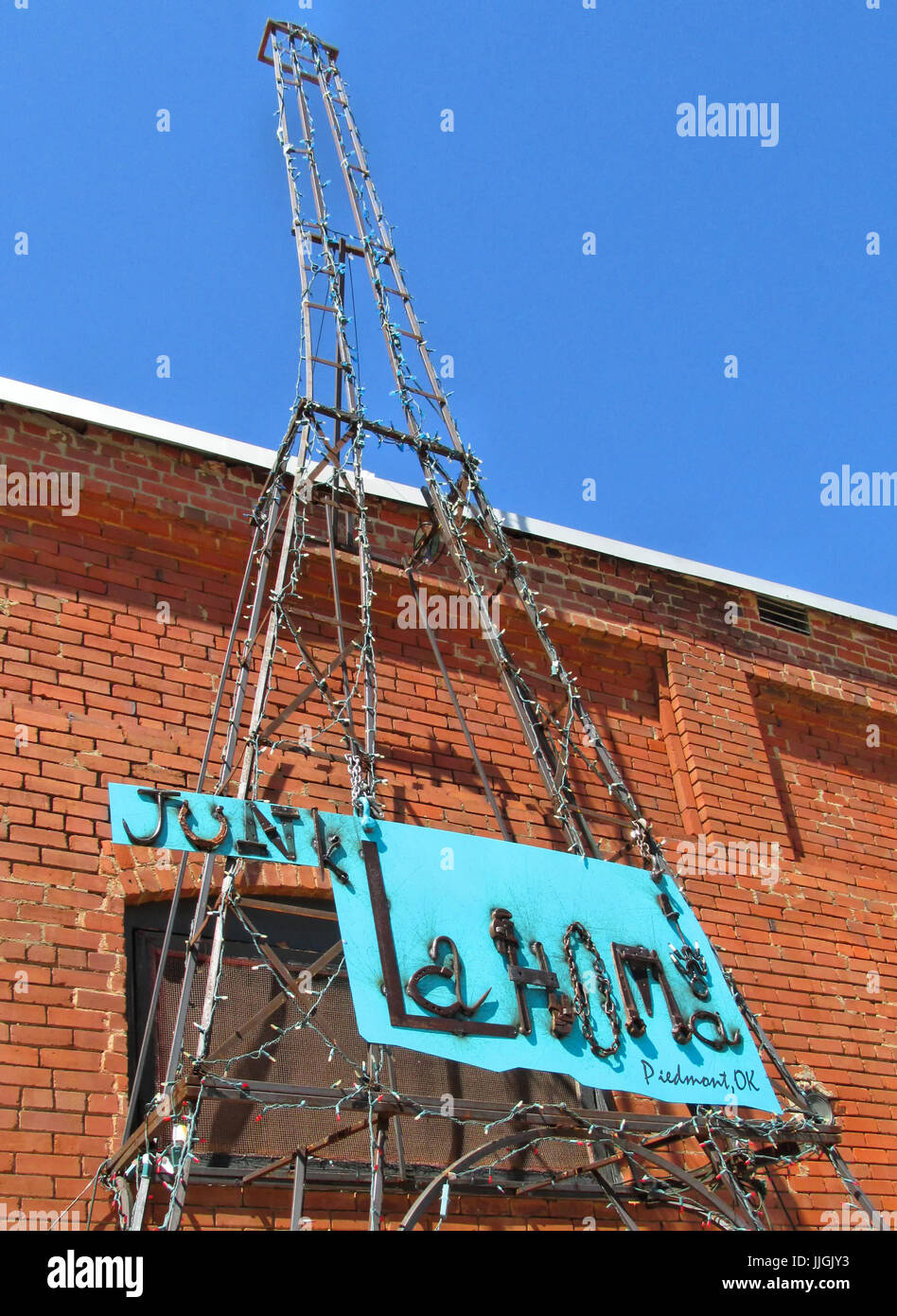 Un metallo Torre Eiffel look-alike stand con segno Junklahoma presso un negozio di antiquariato in Piemonte Oklahoma. Foto Stock