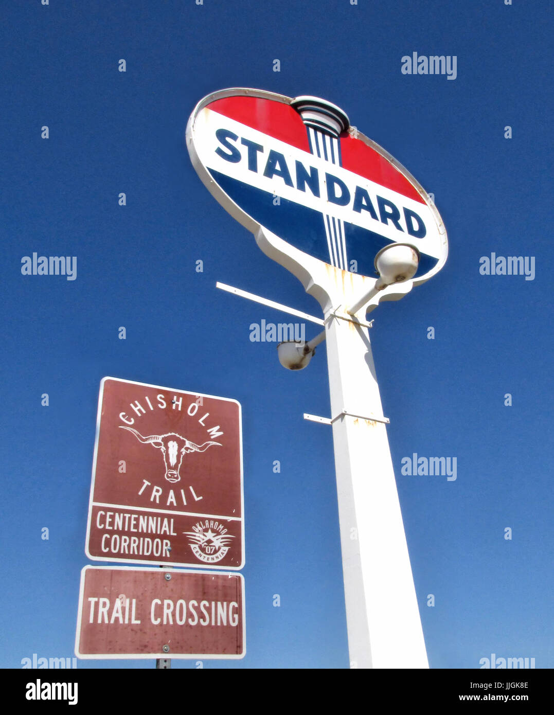 Un vecchio Standard Oil gas station segno e un Chisholm segnavia stare fianco a fianco in Yukon Oklahoma. Foto Stock