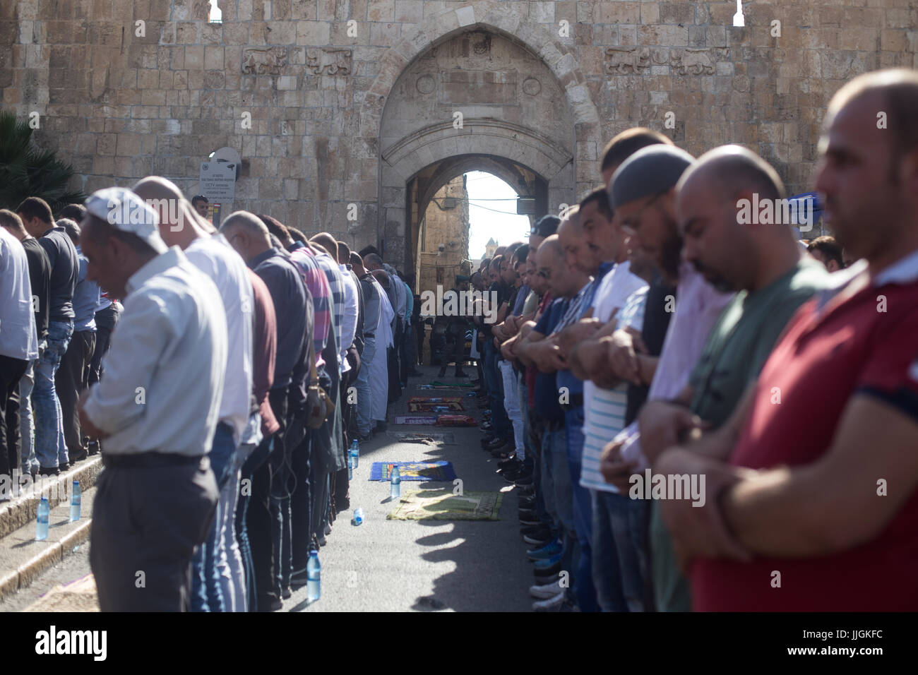 Gerusalemme, Israele. 19 Luglio, 2017. 19.07.17 Porta del Leone, Gerusalemme- musulmano di attesa del pomeriggio preghiera fuori Porta del Leone come polizia israeliana a guardare. Scontri tra manifestanti musulmani e forze di polizia al di fuori della Porta del Leone in Gerusalemme la città vecchia. Credito: Louise Wateridge/Pacific Press/Alamy Live News Foto Stock