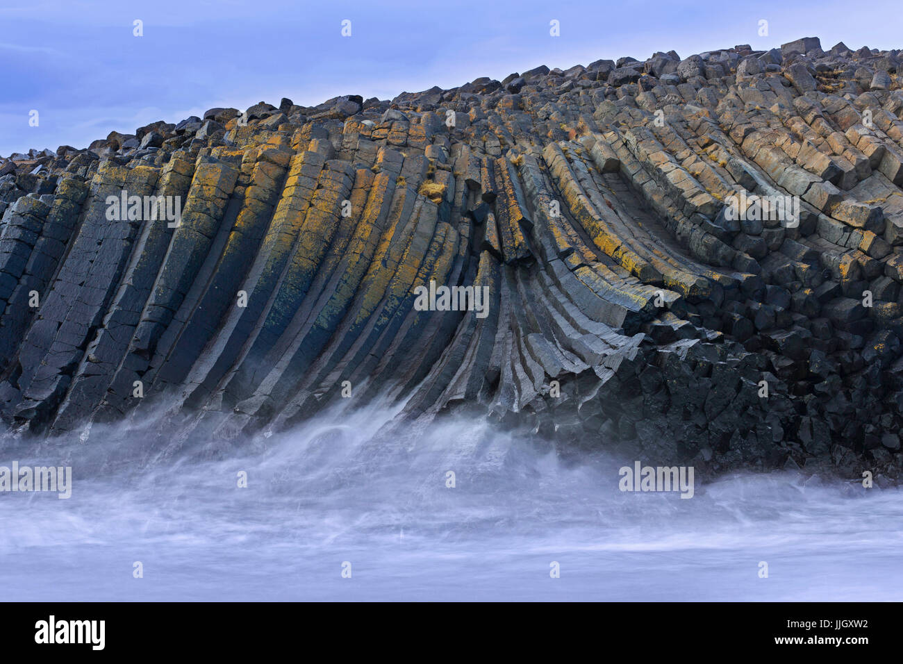 Onde che si infrangono sulle colonne di basalto vulcanico, formazioni di lava in scogliera sul mare vicino Kalfshamarsvik cove, Kalfshamar Penisola, Skagi, Islanda Foto Stock