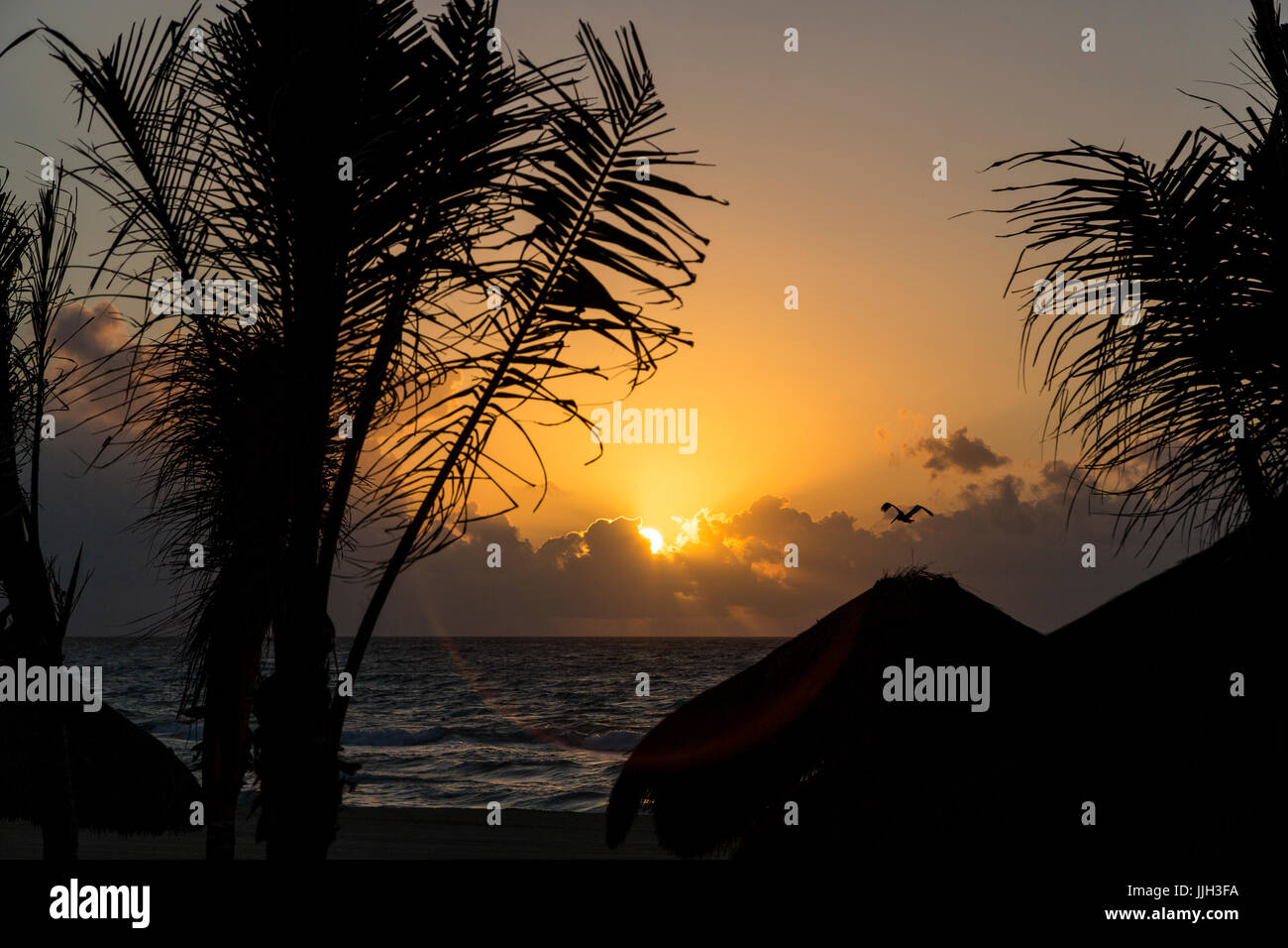Il sole sorge sopra le nuvole all'orizzonte in Playa Del Carmen, Messico. Foto Stock