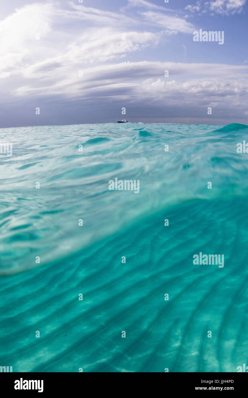 Split-shot mostra ondulazioni di sabbia e nuvole tropic presso la spiaggia di North Bimini, Bahamas. Foto Stock