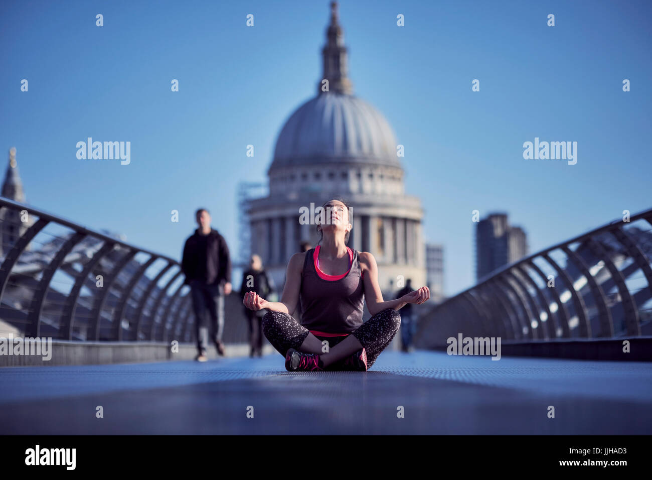 Una donna meditando il Millennium Bridge con la Cattedrale di St Paul in background. Foto Stock