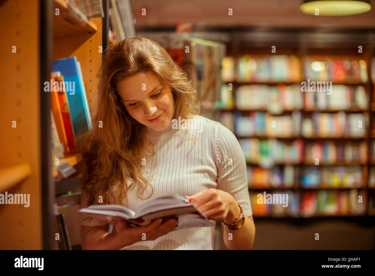 Una giovane donna accede in un book store. Foto Stock
