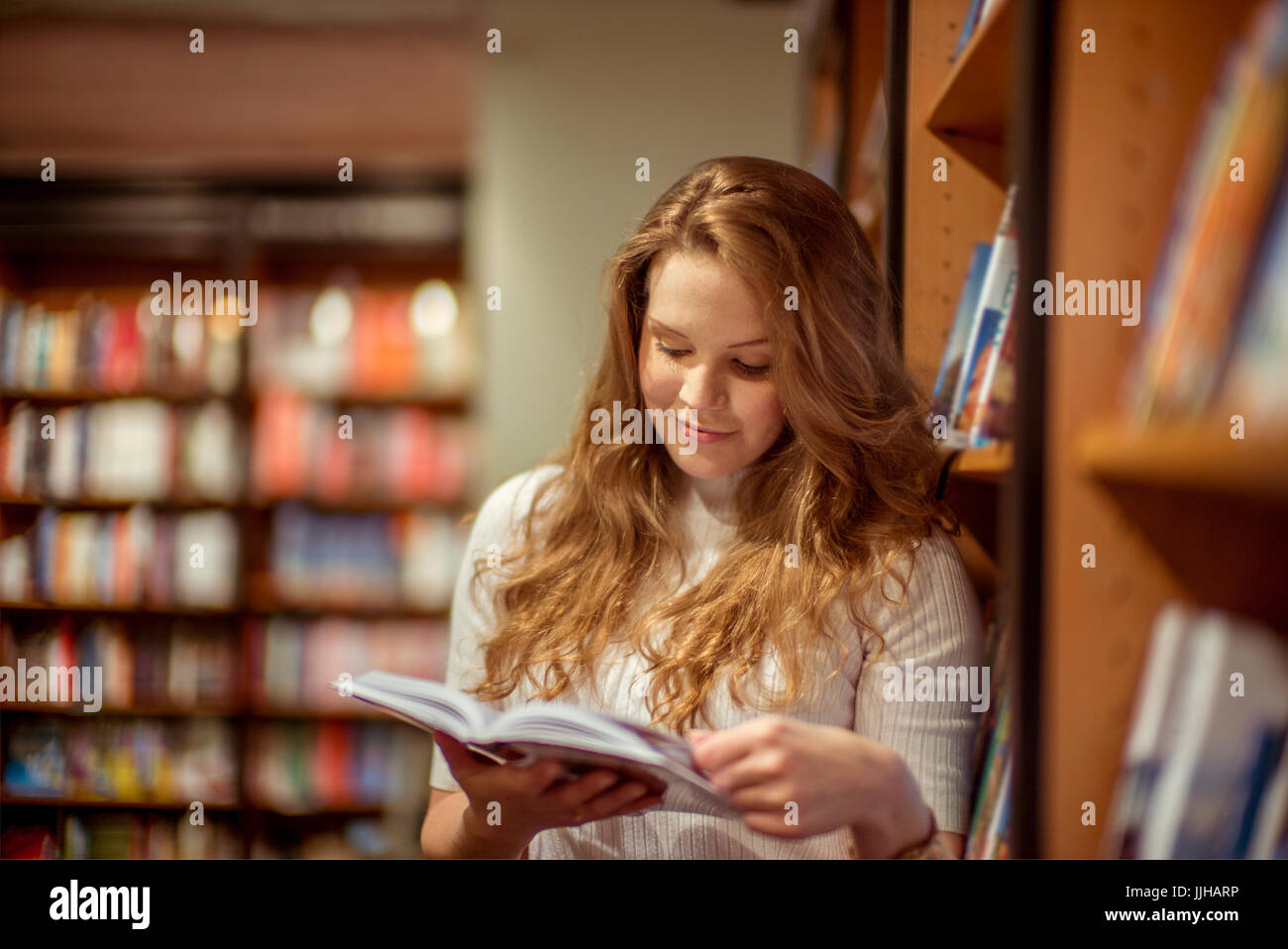 Una giovane donna accede in un book store. Foto Stock