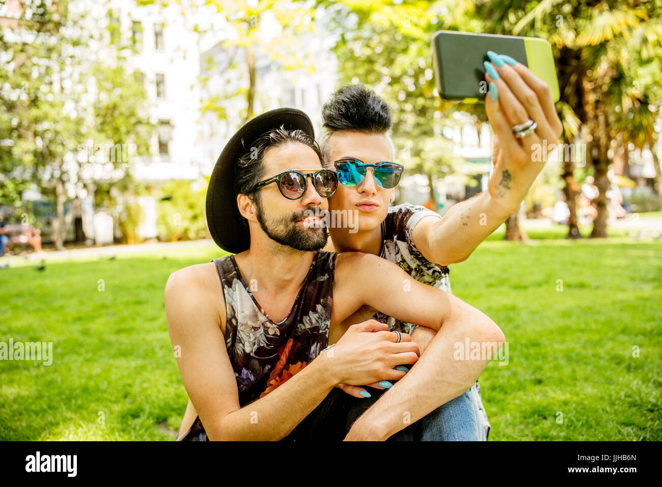 Una coppia gay selfies prendendo in un parco a Londra. Foto Stock
