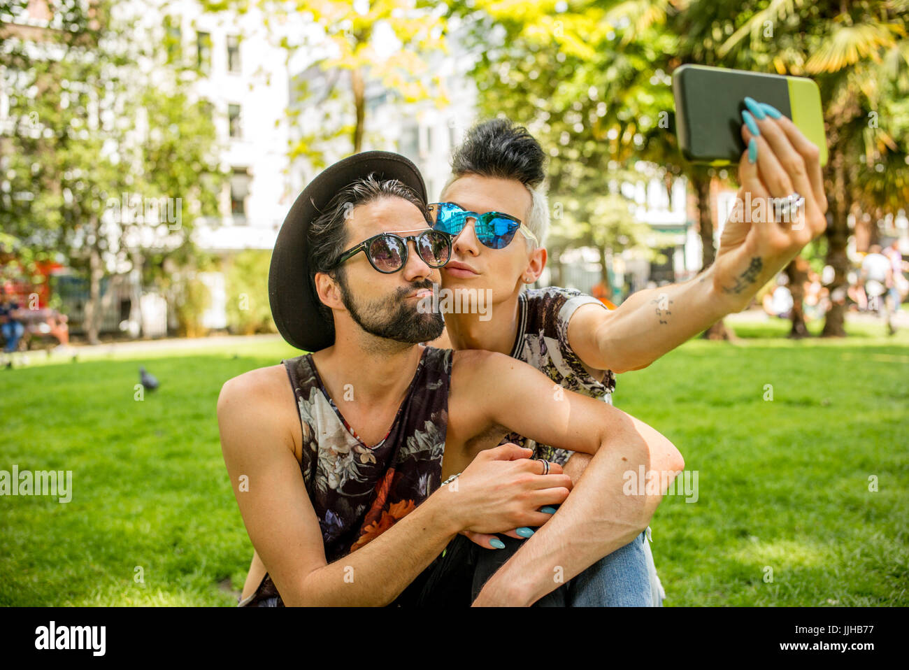 Una coppia gay selfies prendendo in un parco a Londra. Foto Stock