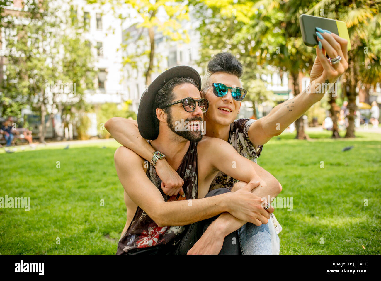 Una coppia gay selfies prendendo in un parco a Londra. Foto Stock