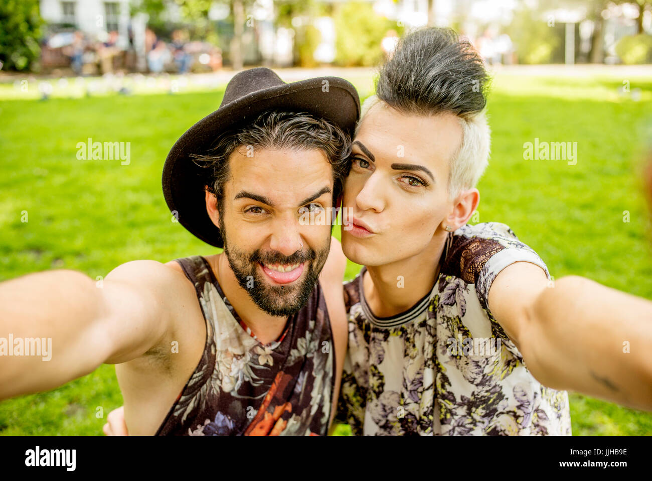 Una coppia gay selfies prendendo in un parco a Londra. Foto Stock