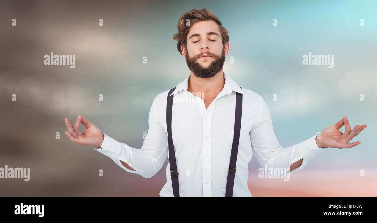 Uomo millenario meditando contro blu sfocate sfondo marrone Foto Stock