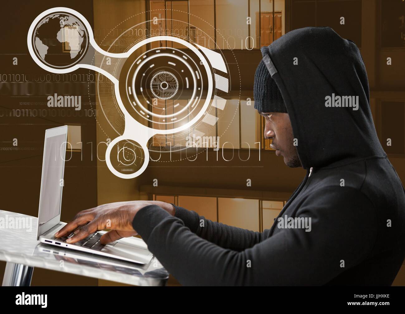 Vista laterale di hacker tramite un computer portatile in edificio anteriore Foto Stock