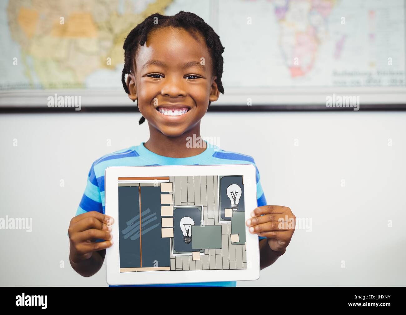 Ragazzo che sorride con la compressa sulle mani, che mostra l'estrazione dell'ufficio sul suo tablet (colore: blu scuro Foto Stock