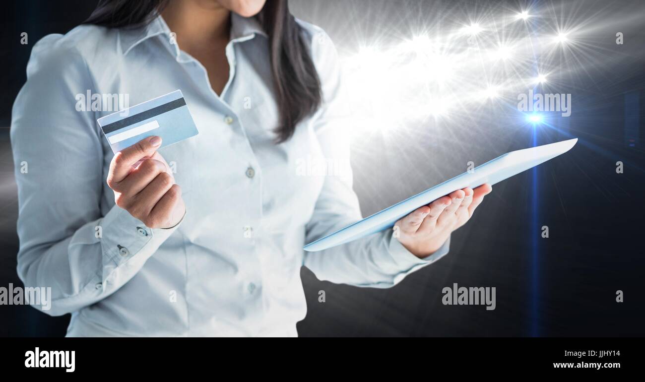 Parte di una donna guarda una tavoletta digitale schermo con una carta di debito Foto Stock