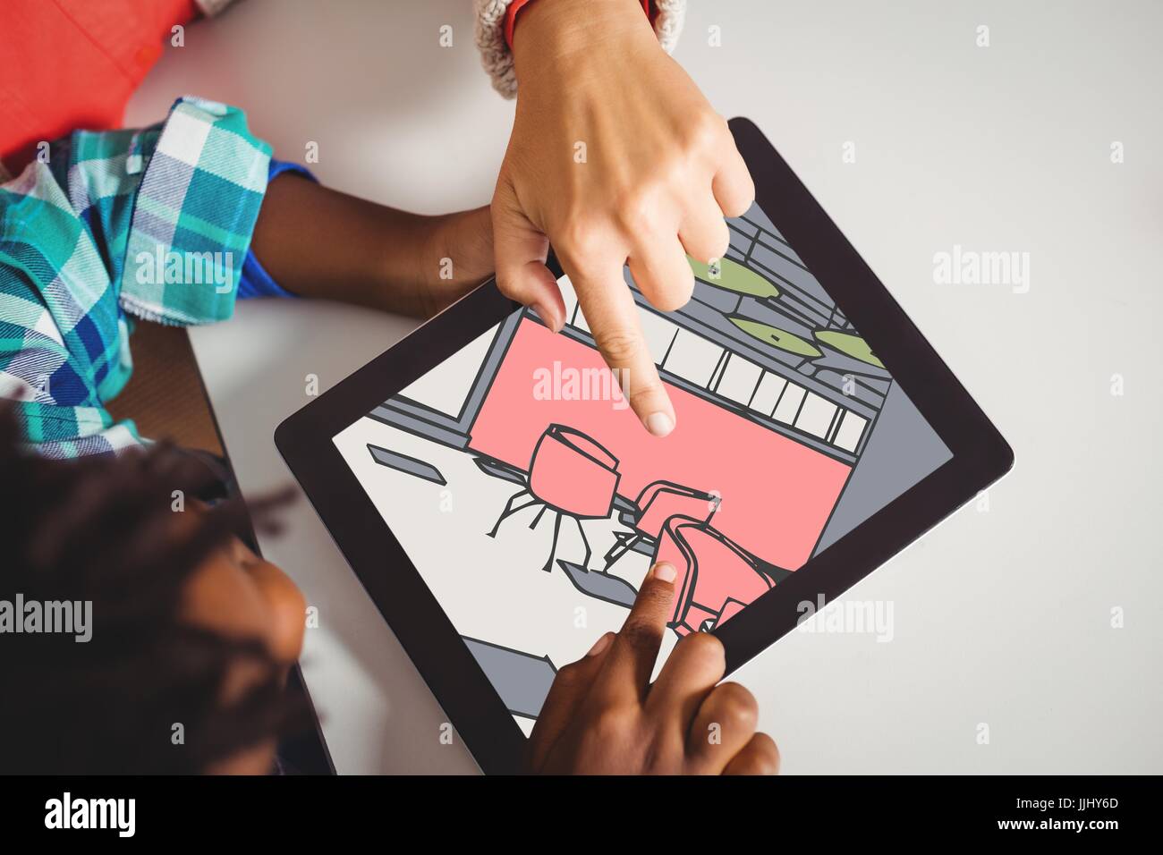 Due persone che guardano 3D disegni su una tavoletta digitale Foto Stock