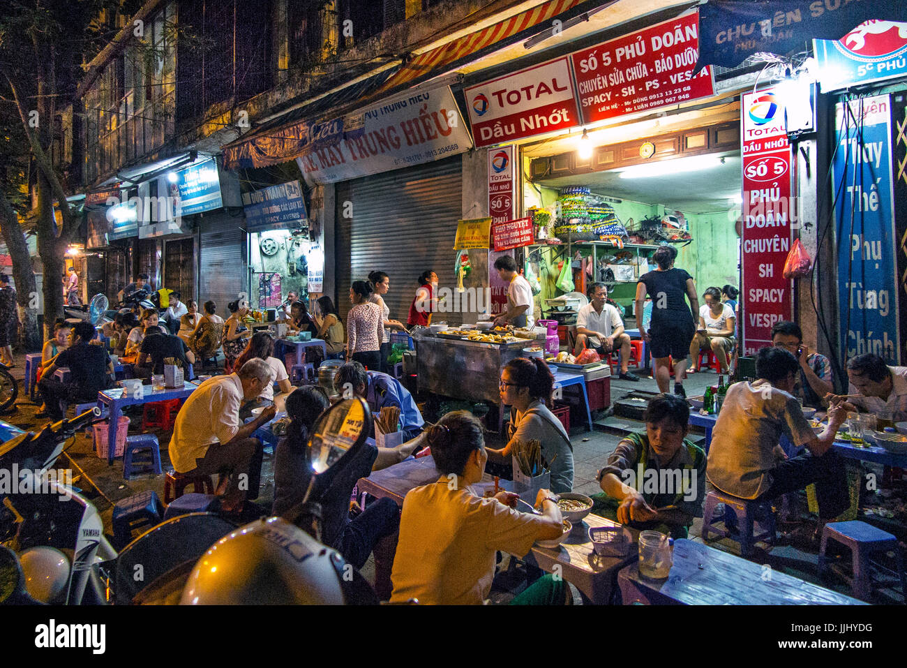 Sala da pranzo di persone su strada, Hanoi Vietnam Foto Stock