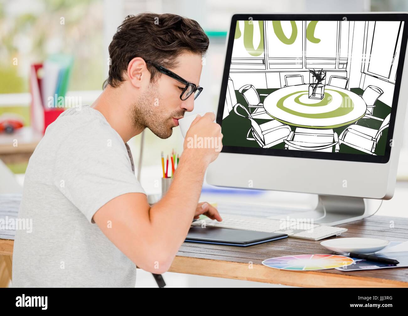 Giovane uomo prendendo un caffè. Computer dietro con la nuova sala riunioni linee di progettazione. Foto Stock