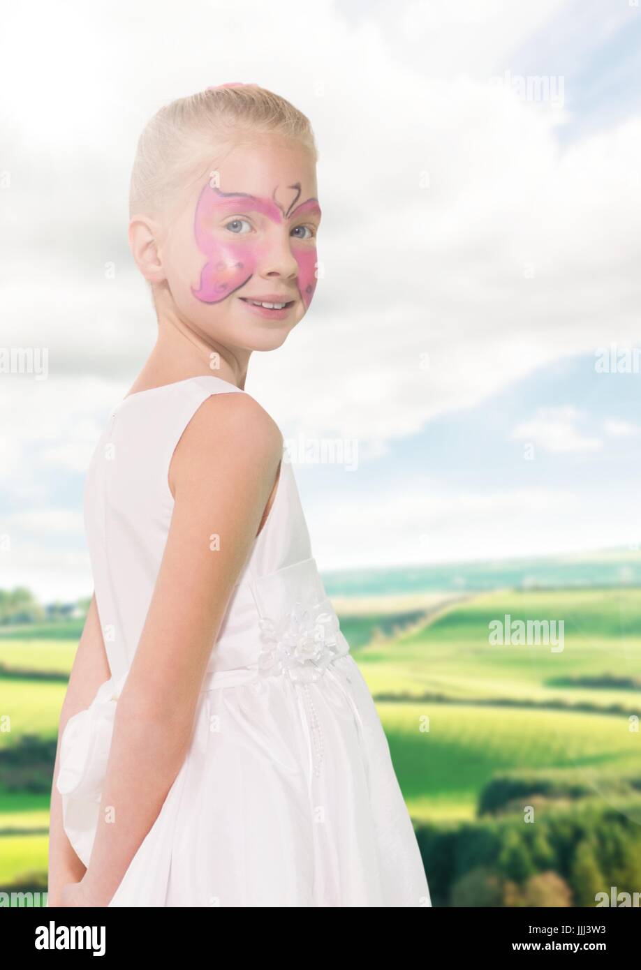 Ragazza in rosa facepaint contro i campi con flare Foto Stock