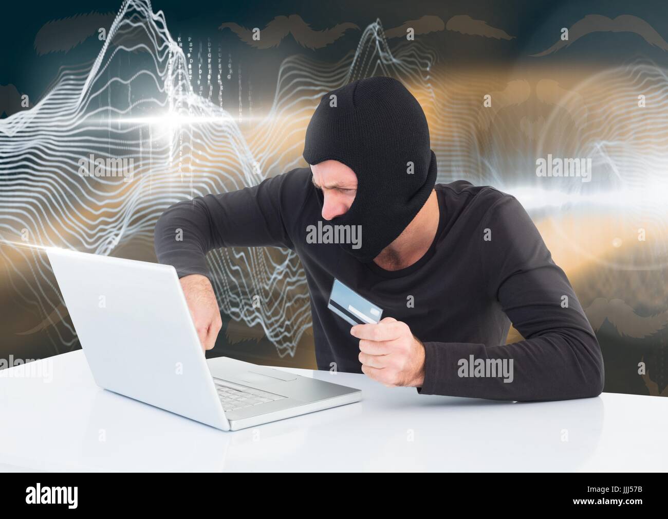 Il pirata informatico con una carta di credito lavorando sul computer portatile di fronte a sfondo digitale Foto Stock