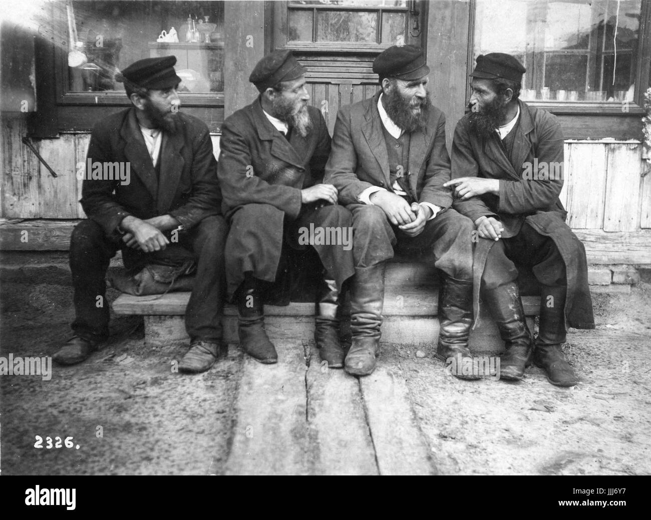Krasilov, Ucraina (russo / Polacco shtetl o villaggio ebraico ).c. 1916-17. Gli uomini ebrei seduta al di fuori del negozio di parlare Foto Stock
