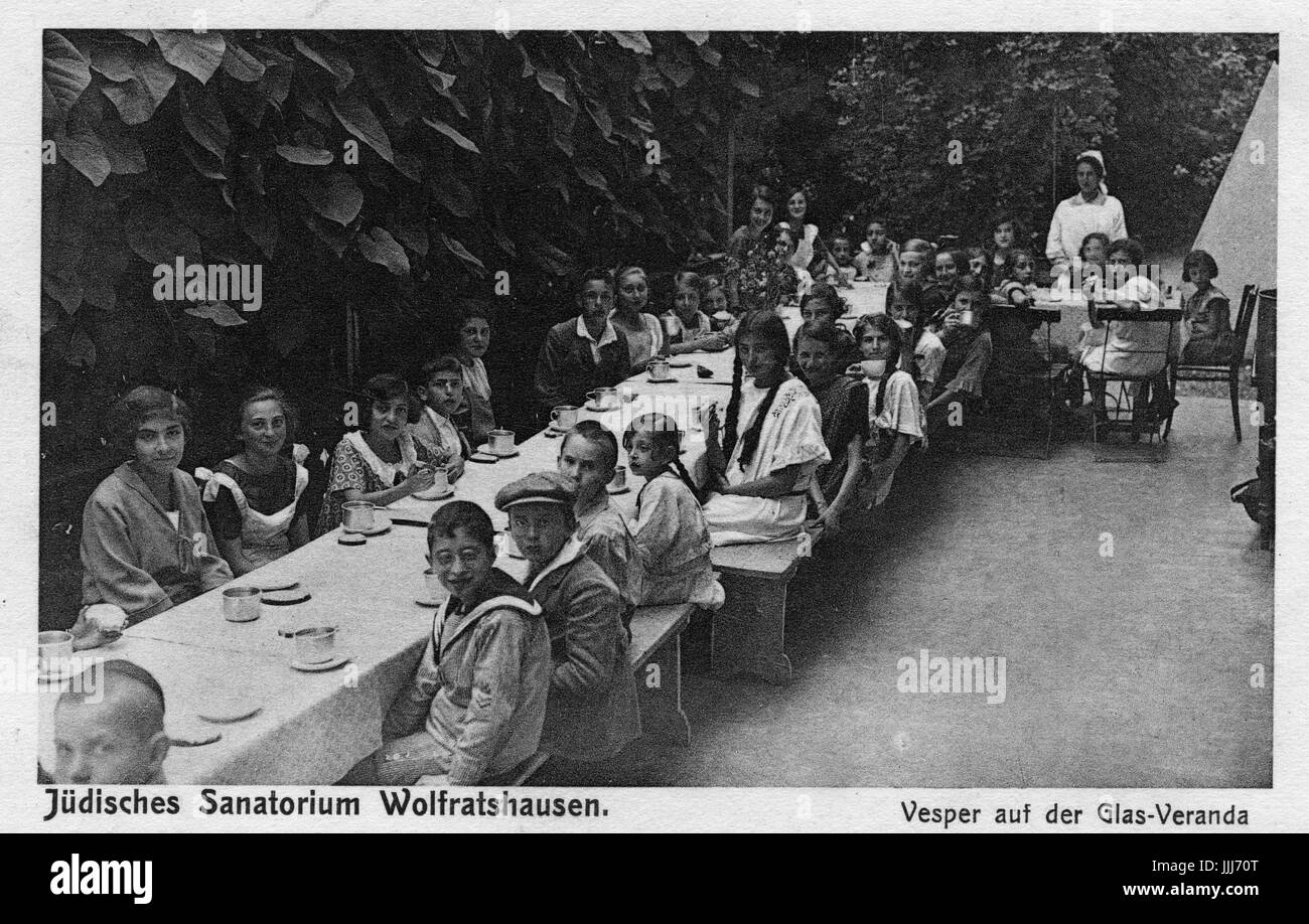 Sanitorium ebraica a Wolfratshausen per bambini in Baviera.. La didascalia recita "Judisches sanatorio wolfratshausen. Vesper auf der Glas-Veranda'. Inversione di marcia della cartolina stampigliato 1928. Foto Stock