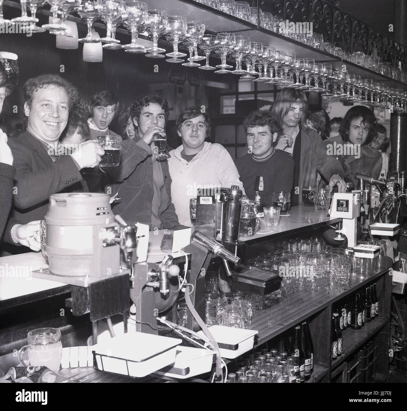 1970s, Inghilterra, un gruppo di università maschili o di sudori universitari che bevono birra in un bar, divertendosi durante la settimana del rog. Foto Stock