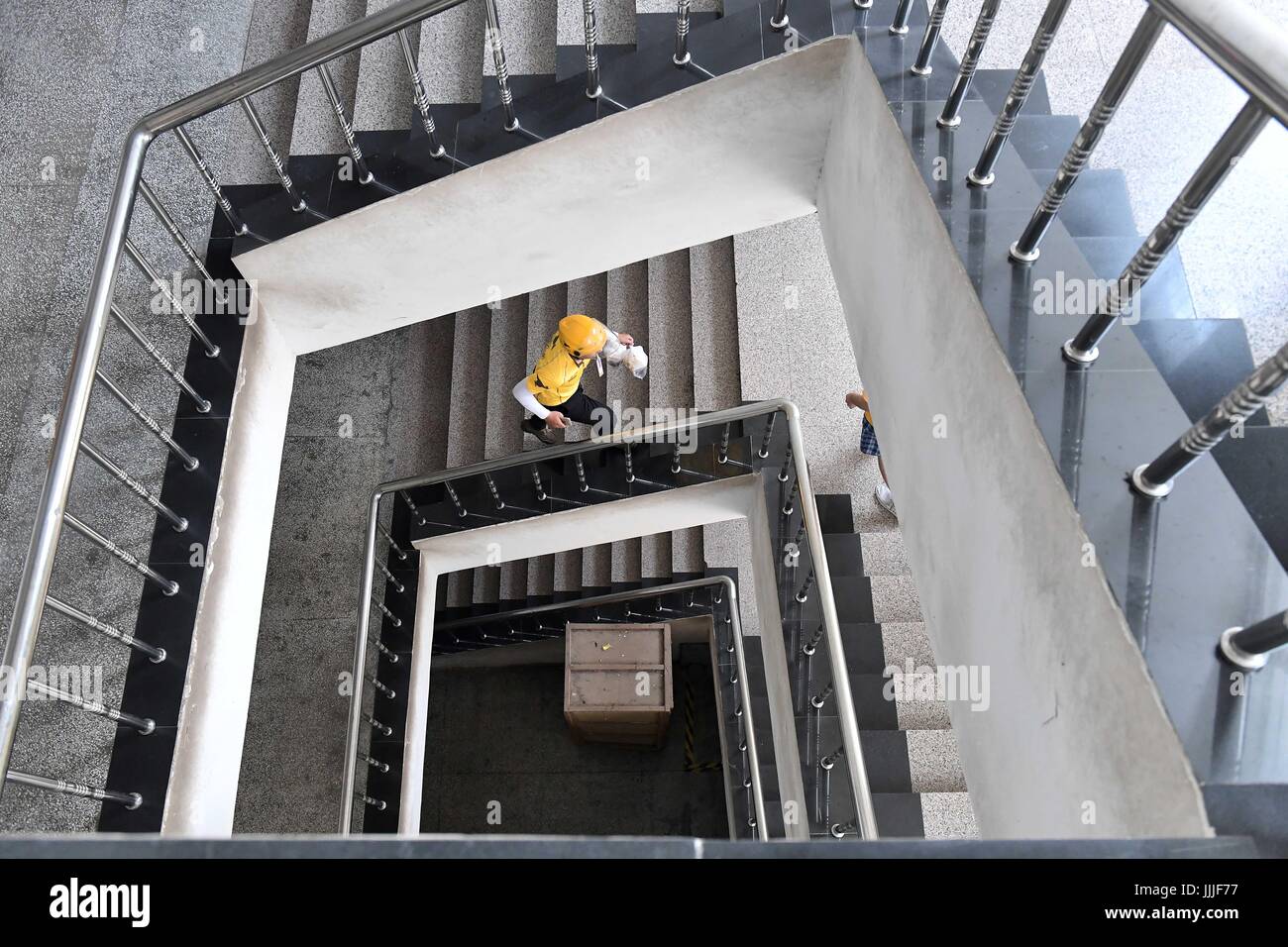 (170720) -- JINAN, luglio 20, 2017 (Xinhua) -- Delivery Guy Li Gan sale al piano di sopra per fornire cibo di Jinan, città capitale della Cina dell'est della provincia di Shandong, 20 luglio 2017. Un allarme giallo per il calore è stato pubblicato qui il giovedì. (Xinhua/Guo Xulei) (lx) Foto Stock