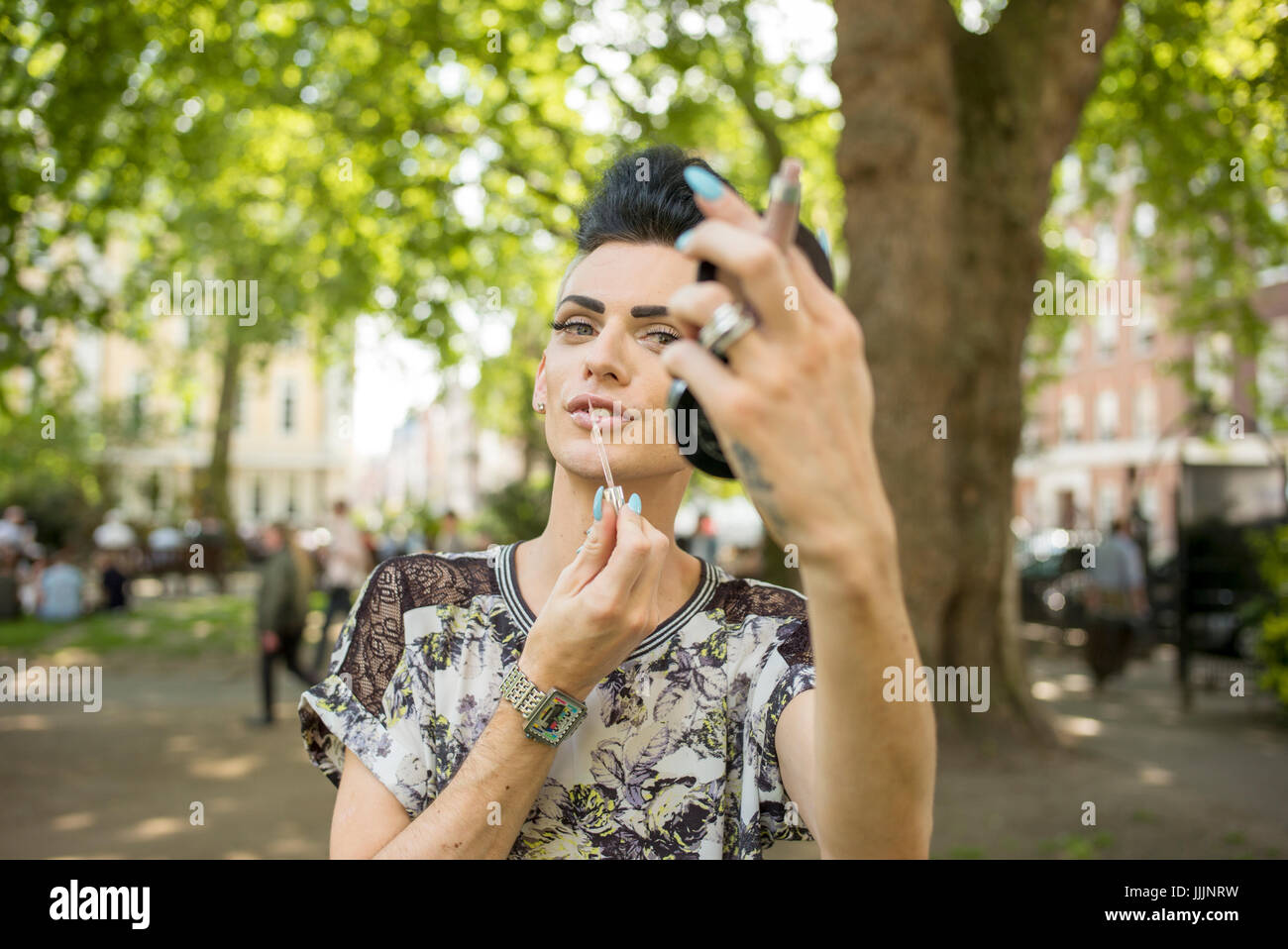 Un uomo gay applica la sua make up. Foto Stock