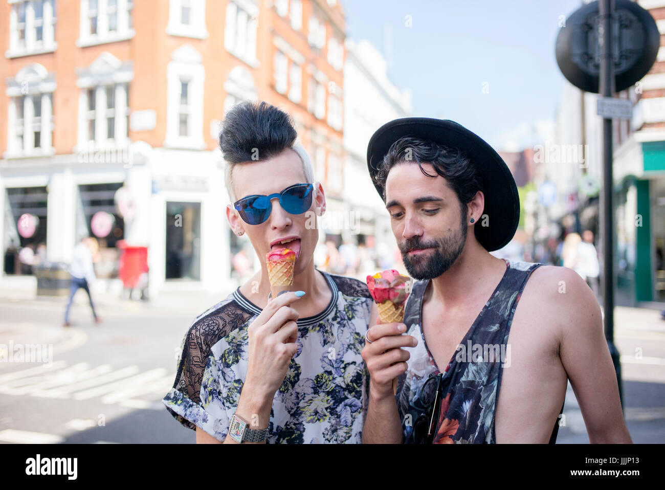 Una coppia gay gustare un gelato in una giornata fuori a Londra. Foto Stock