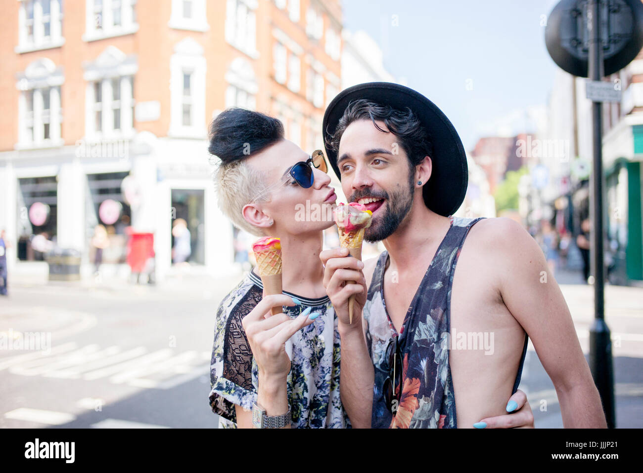 Una coppia gay gustare un gelato in una giornata fuori a Londra. Foto Stock
