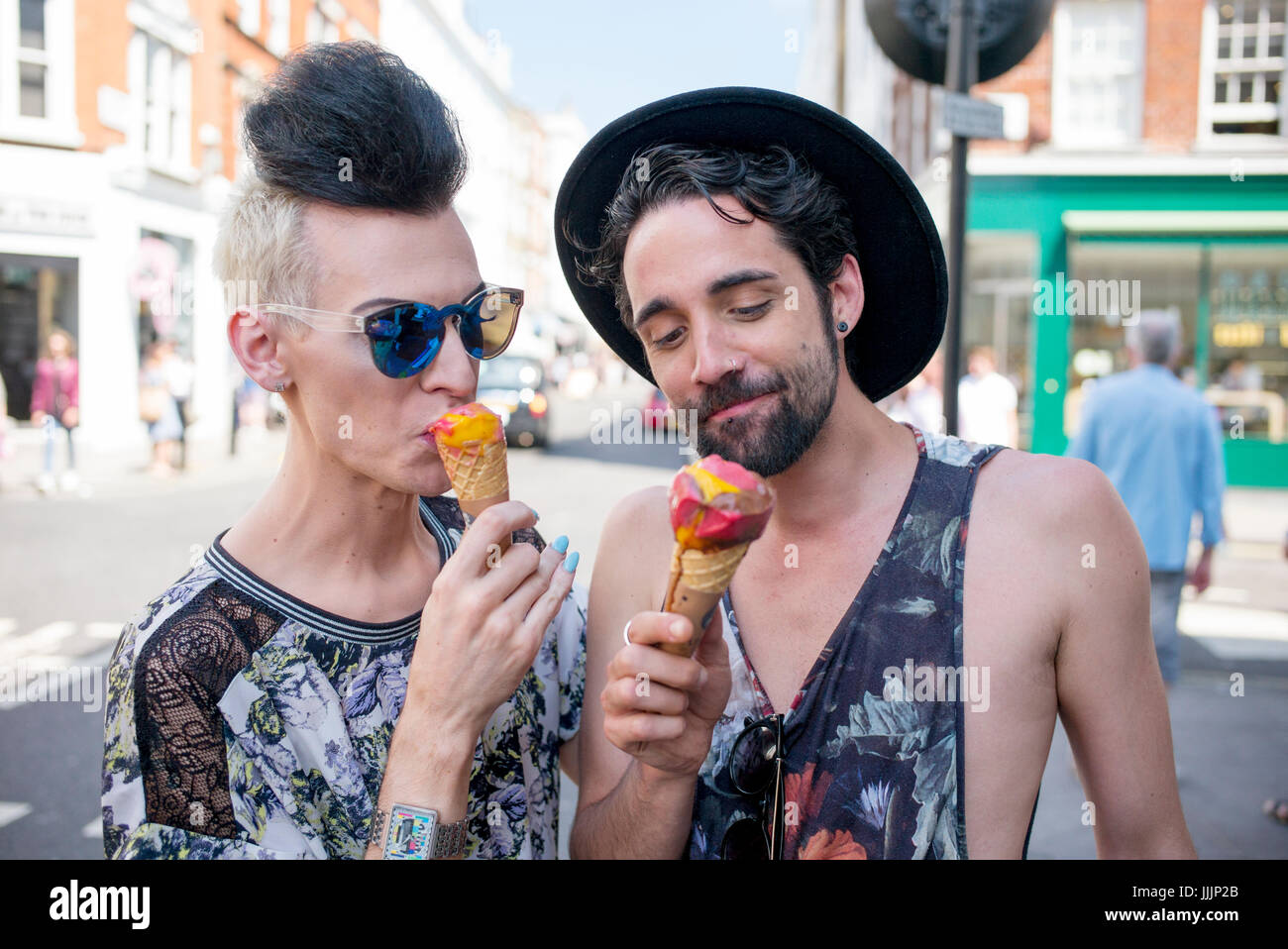 Una coppia gay gustare un gelato in una giornata fuori a Londra. Foto Stock